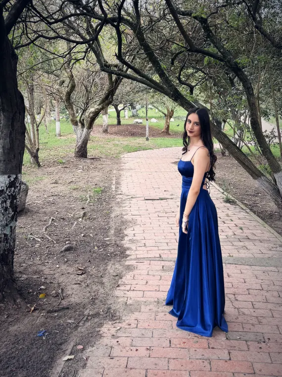 Paula mira por encima del hombro en un sendero bajo los árboles