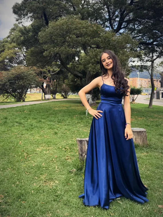 Paula de pie en el parque, con la mano en la cintura